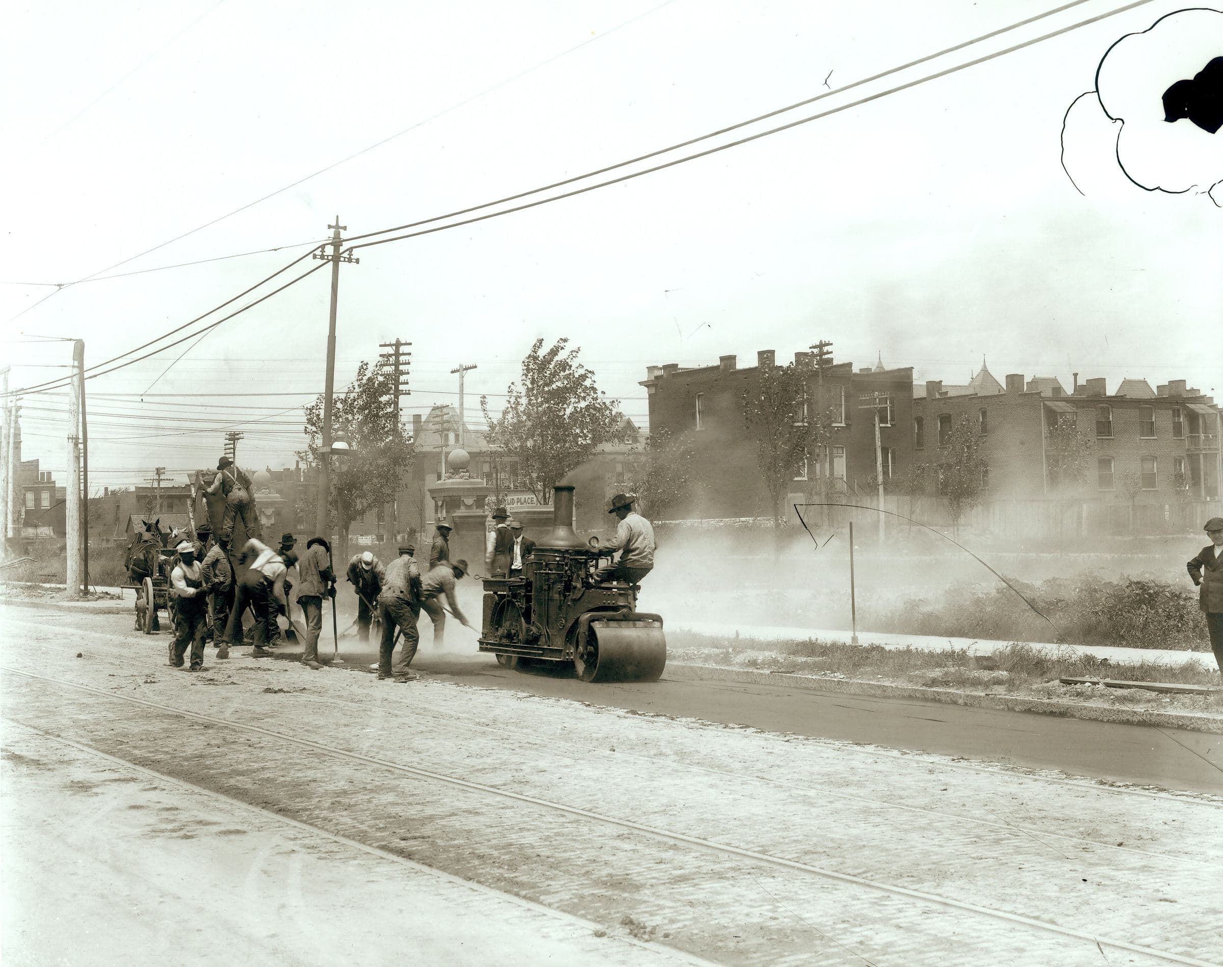 A road crew laying asphalt on a city street, historic photograph