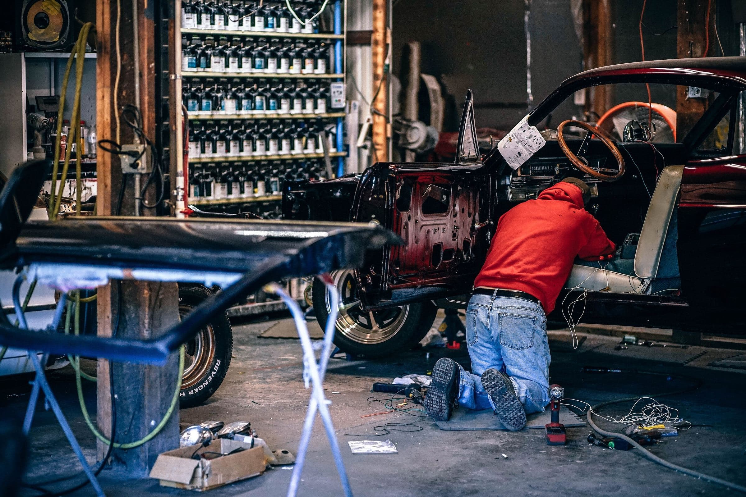 A mechanic at work in a car restoration shop